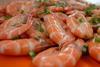 The image shows cooked fresh prawns on a plate seasoned with parsley