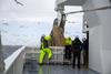 Fishermen hauling in a herring catch on board a fishing vessel in the North Sea