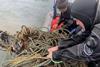 Divers hauling in ghost gear on to a vessel