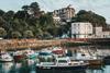 The image shows boats moored near to the shore at Folkstone Harbour