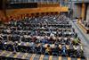The image shows an overhead shot of the members attending the entry-into-force ceremony on 15 September