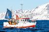 The image shows a Norwegian fishing vessel on the water with the snowy coastline in the background