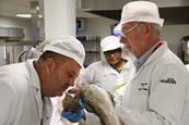 A training participant smells a fish to determine its quality
