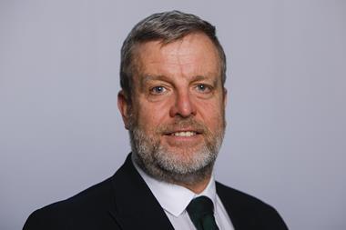 The image shows a headshot of Finlay Carson MSP in a black suit and tie