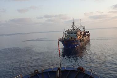 Fishing vessel being towed at sea