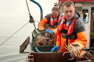 Brian Chambers on board a fishing vessel landing a large crab
