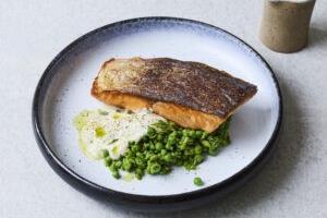Crispy salmon with beurre blanc, crushed peas and parsley oil using salmon supplied by BAP-certified producer Hiddenfjord