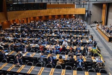 The image shows an overhead shot of the members attending the entry-into-force ceremony on 15 September
