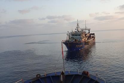 Fishing vessel being towed at sea