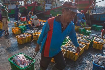 The image shows an Indonesian fisher on board a vessel