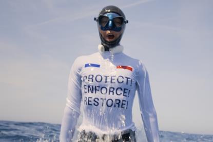 Alessia Zecchini, freediver, wearing a vest saying PROTECT! ENFORCE! RESTORE! to protest against French bottom trawling