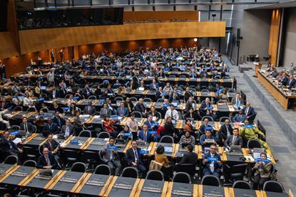 The image shows an overhead shot of the members attending the entry-into-force ceremony on 15 September