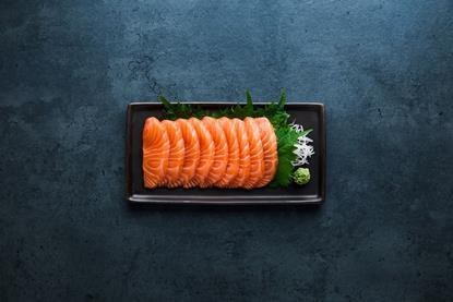 Sashimi laid on a black oblong plate