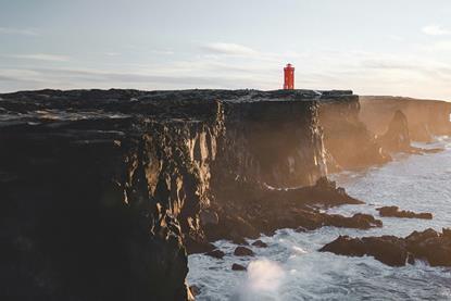 A red lighthouse on a cliff