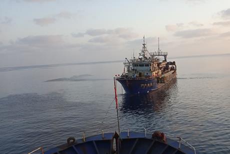 Fishing vessel being towed at sea