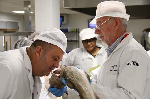 A training participant smells a fish to determine its quality