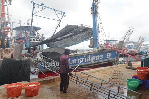 The image shows a Thai fishing vessel on the quayside