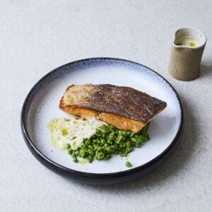 Crispy salmon with beurre blanc, crushed peas and parsley oil using salmon supplied by BAP-certified producer Hiddenfjord