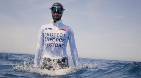 Alessia Zecchini, freediver, wearing a vest saying PROTECT! ENFORCE! RESTORE! to protest against French bottom trawling