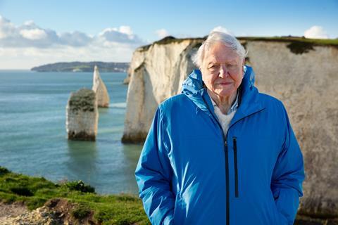Image of Sir David Attenborough standing by the coast to promote his 'Ocean' film