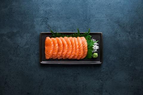 Sashimi laid on a black oblong plate