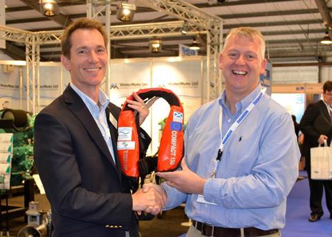 Mark Hart presents one of the lifejackets to Derek Cardno, Marine Safety and Training officer at the SFF