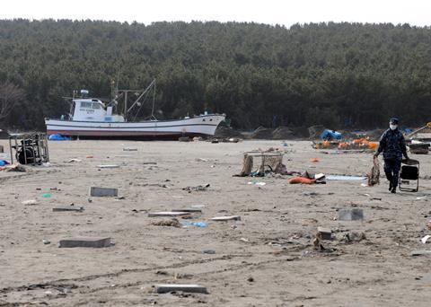 A Sailor assigned to Naval Air Facility Misawa carries debris to a dumpsite during a cleanup effort at the Misawa Fishing Port. Credit: US Navy photo by Mass Communication Specialist 2nd Class Devon Dow