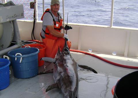 James Barbour, NOAA fishing gear researcher, holds a swordfish. Credit: NOAA