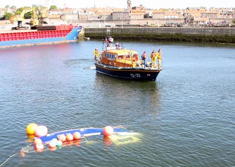 Berwick all-weather lifeboat with the upturned fishing boat. Credit: RNLI/Michael Avril
