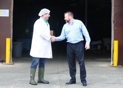 KEDC CEO Conrad Browne, (right), shakes hands with Bruce Dirom, president and CEO of Hardy Buoys Smoked Fish Inc. in front of the future location of the new cold storage facility