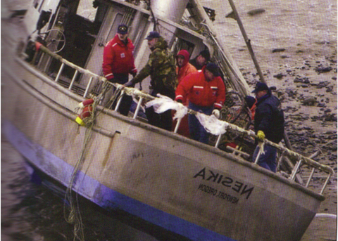 Nesika, beached after capsising, with Coast Guard personnel onboard